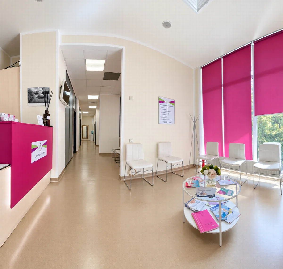 Sala de așteptare a clinicii, cu scaune albe lângă ferestre
